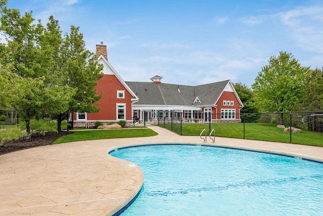 view of swimming pool featuring a yard, a patio area, fence, and a fenced in pool