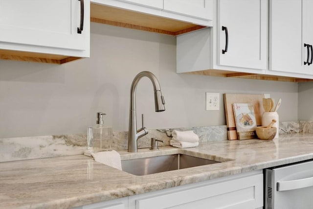 83 Jamestown Dr Unit 83, Springfield, MA 01108 - kitchen with a sink, stainless steel dishwasher, white cabinetry, and light stone counters