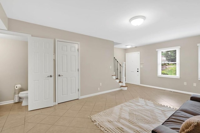 83 Jamestown Dr Unit 83, Springfield, MA 01108 - living room with light tile patterned flooring, stairway, and baseboards
