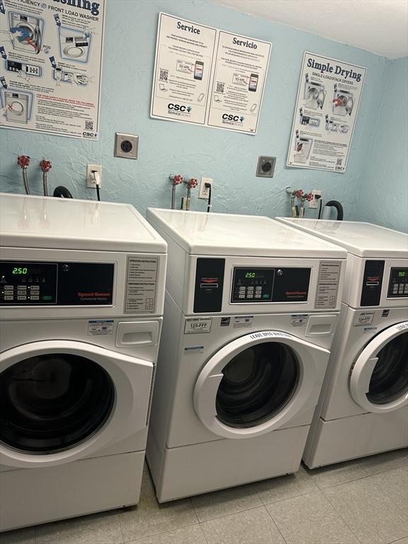 laundry room with washing machine and dryer and light tile patterned floors