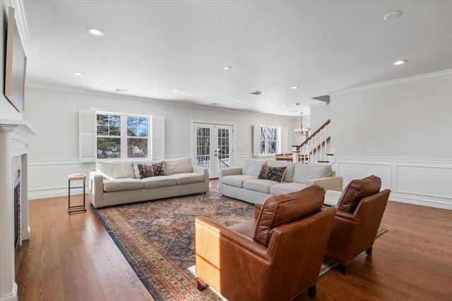 living area with a fireplace, stairway, wood finished floors, and french doors