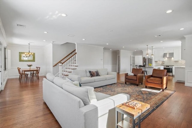 living room featuring ornamental molding, wood finished floors, visible vents, and recessed lighting