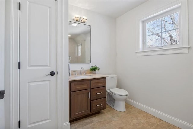 bathroom featuring toilet, a closet, vanity, and baseboards