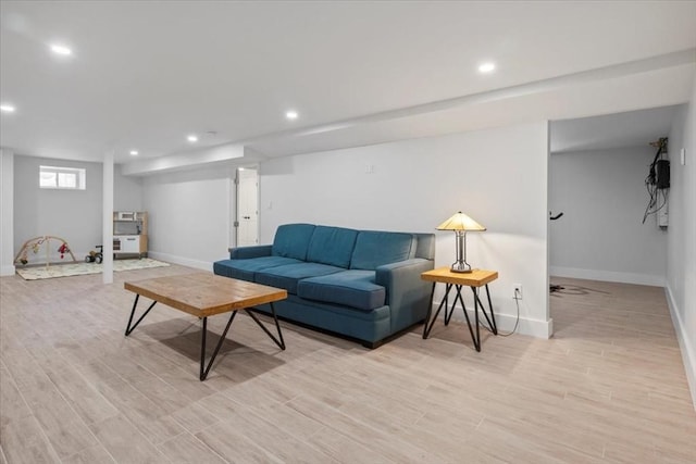 living room with light wood-type flooring, baseboards, and recessed lighting