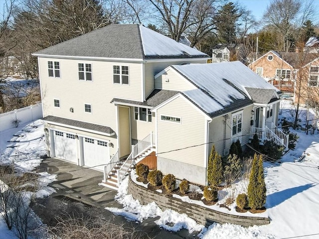 view of front facade featuring driveway, an attached garage, and a shingled roof