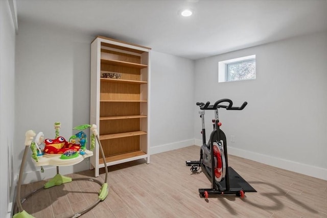 exercise area with light wood finished floors, recessed lighting, and baseboards