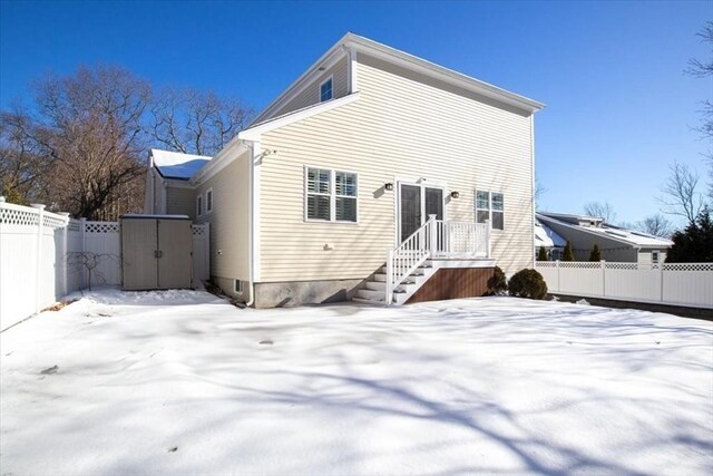 snow covered back of property with fence