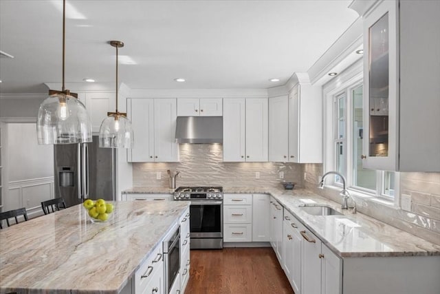 kitchen featuring appliances with stainless steel finishes, white cabinetry, a sink, and under cabinet range hood