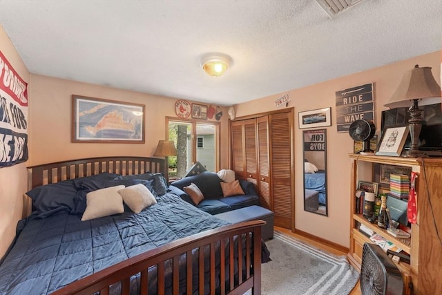 bedroom with a textured ceiling, a closet, and baseboards