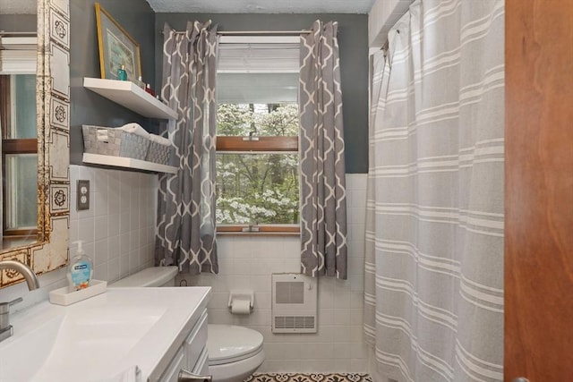 bathroom with tile walls, toilet, a shower with curtain, vanity, and heating unit