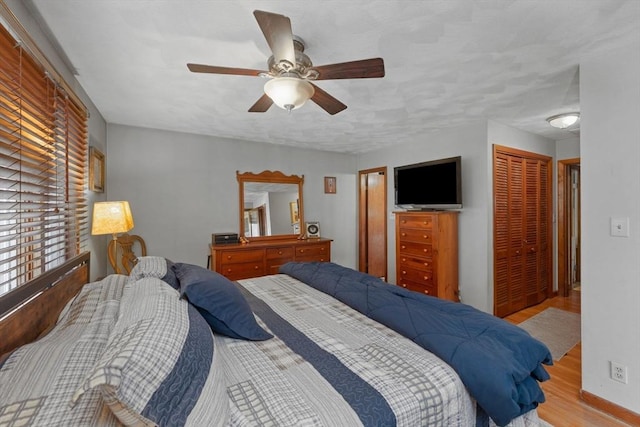 bedroom featuring ceiling fan, a closet, and wood finished floors