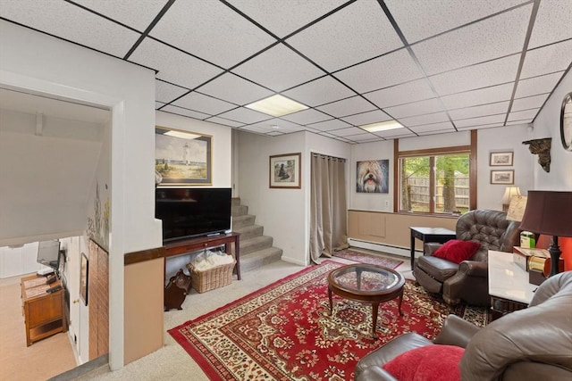 carpeted living area featuring a drop ceiling, baseboard heating, and stairway