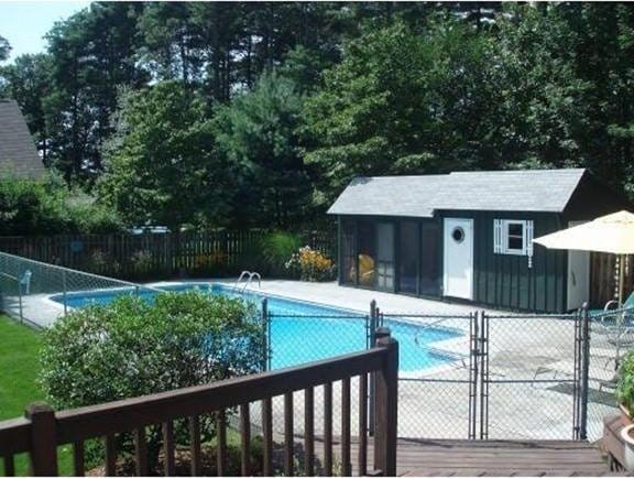view of pool with an outdoor structure, fence, and a fenced in pool