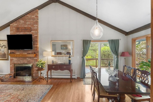 dining room featuring a baseboard radiator, a fireplace, high vaulted ceiling, and wood finished floors