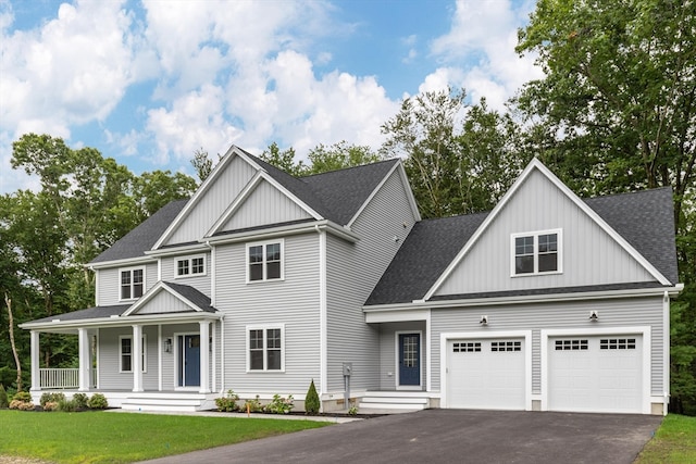 craftsman-style home featuring a garage, a front lawn, and covered porch