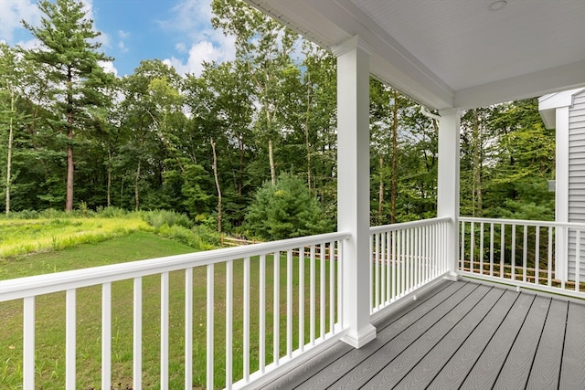 wooden deck featuring covered porch and a yard