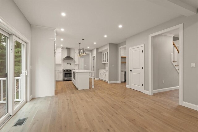 spare room with light wood-type flooring, ornamental molding, a chandelier, and french doors