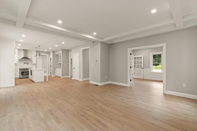 unfurnished living room featuring light wood-type flooring and beam ceiling