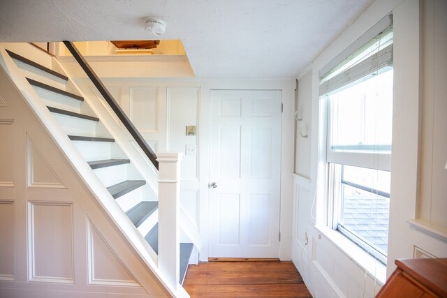 stairs with hardwood / wood-style floors and plenty of natural light