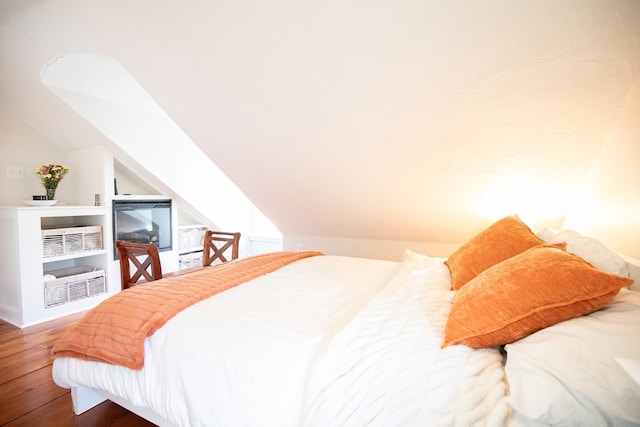 bedroom with wood-type flooring and vaulted ceiling