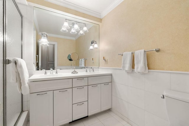 bathroom featuring tile walls, vanity, toilet, crown molding, and tile patterned floors