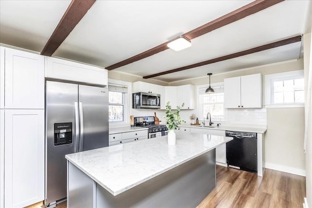 kitchen featuring a center island, white cabinets, hanging light fixtures, and appliances with stainless steel finishes