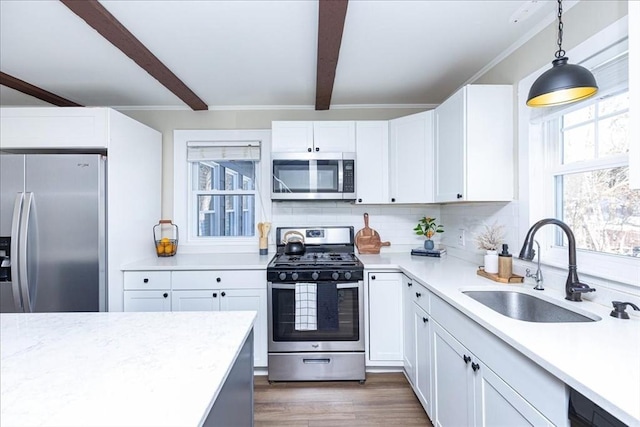 kitchen with white cabinetry, sink, hanging light fixtures, beamed ceiling, and appliances with stainless steel finishes