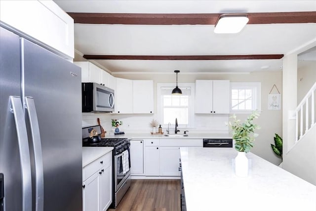 kitchen with white cabinetry, sink, dark wood-type flooring, hanging light fixtures, and appliances with stainless steel finishes