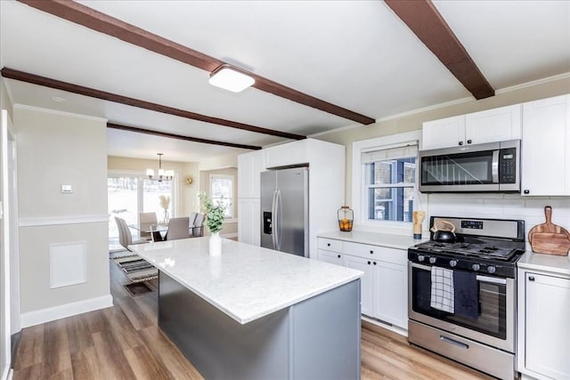 kitchen featuring appliances with stainless steel finishes, light hardwood / wood-style flooring, white cabinetry, and a kitchen island