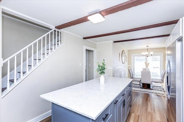 kitchen featuring a center island, hanging light fixtures, beamed ceiling, dark hardwood / wood-style flooring, and stainless steel refrigerator