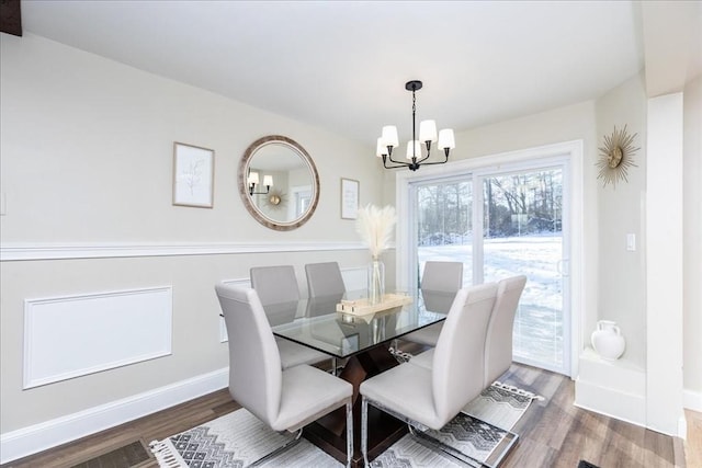 dining room with dark hardwood / wood-style floors and an inviting chandelier