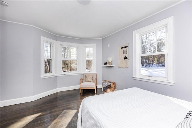 bedroom with multiple windows, dark hardwood / wood-style flooring, and ornamental molding