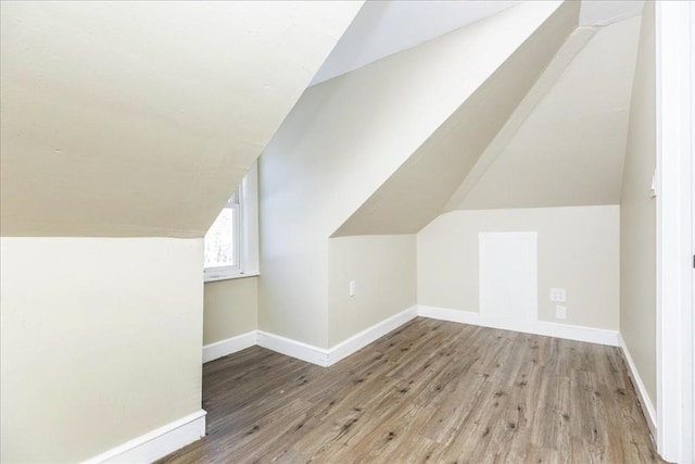 additional living space featuring light hardwood / wood-style floors and lofted ceiling