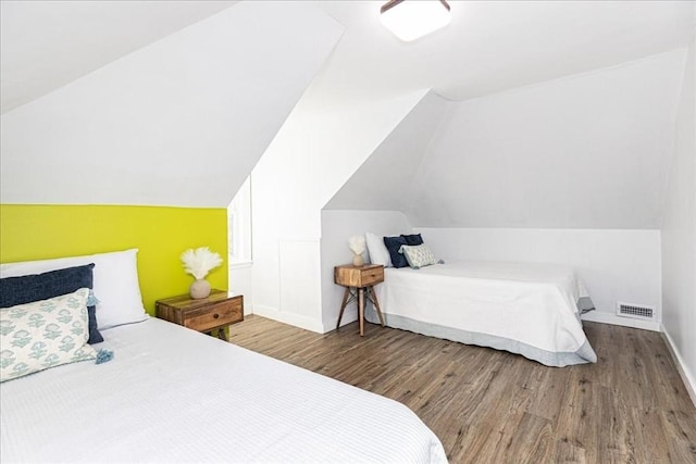 bedroom featuring hardwood / wood-style floors and vaulted ceiling