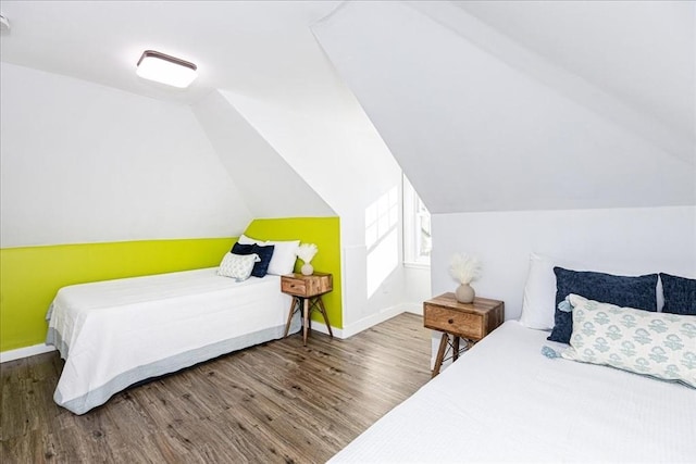 bedroom featuring hardwood / wood-style floors and lofted ceiling