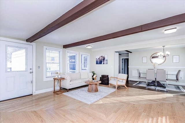 living room with beamed ceiling, a notable chandelier, and light parquet floors