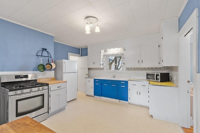 19 Franklin St, Wakefield, MA 01880 - kitchen with appliances with stainless steel finishes, light countertops, white cabinetry, light flooring, and backsplash