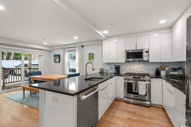 11 Cameron St Unit 1, Brookline, MA 02445 - kitchen featuring stainless steel appliances, a sink, a peninsula, modern cabinets, and light wood-type flooring