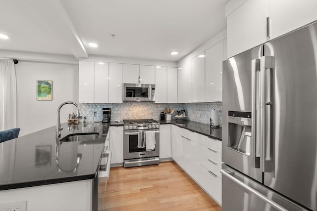 11 Cameron St Unit 1, Brookline, MA 02445 - kitchen with appliances with stainless steel finishes, a sink, modern cabinets, dark countertops, and recessed lighting