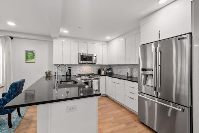 11 Cameron St Unit 1, Brookline, MA 02445 - kitchen with appliances with stainless steel finishes, a sink, a peninsula, recessed lighting, and white cabinetry