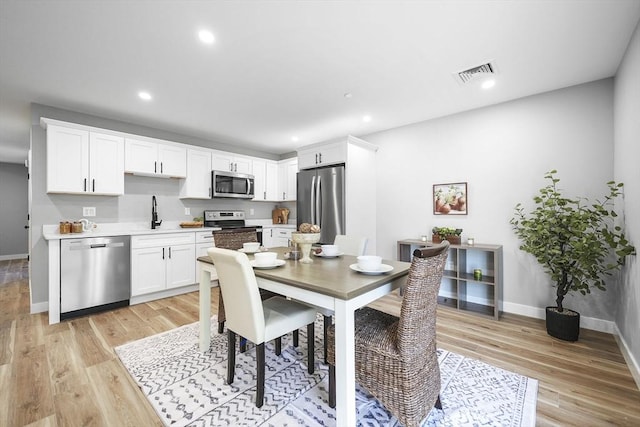 dining room featuring sink and light hardwood / wood-style floors