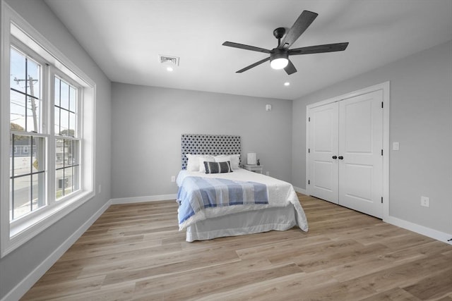 bedroom with a closet, ceiling fan, and light wood-type flooring