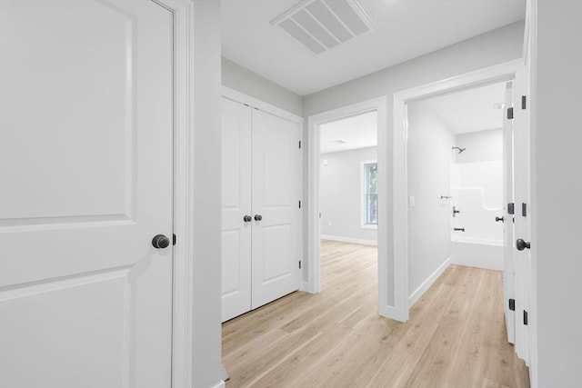 corridor with light hardwood / wood-style flooring