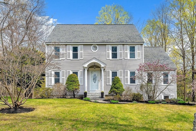colonial-style house with a front lawn and roof with shingles