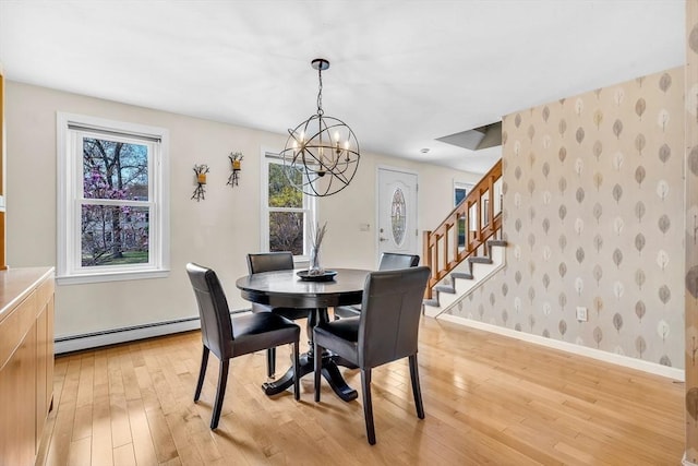 dining room with an inviting chandelier, baseboards, baseboard heating, wallpapered walls, and light wood-type flooring