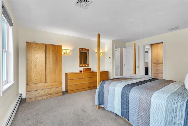 bedroom featuring visible vents, baseboard heating, multiple windows, and light colored carpet