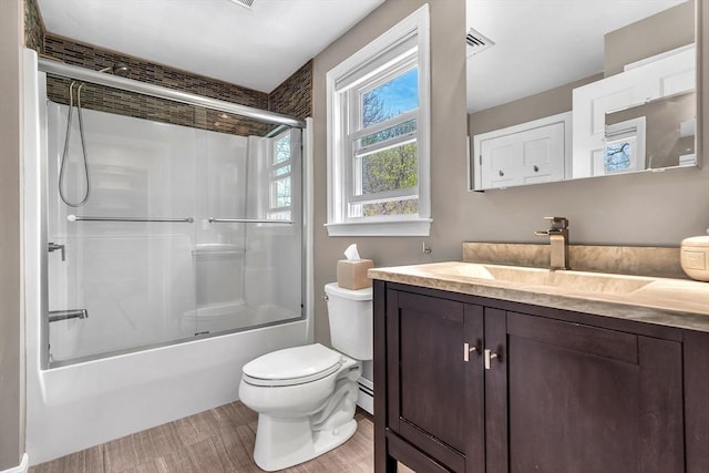 bathroom featuring vanity, bath / shower combo with glass door, wood finished floors, and toilet
