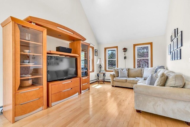 living room featuring high vaulted ceiling and light wood-style floors