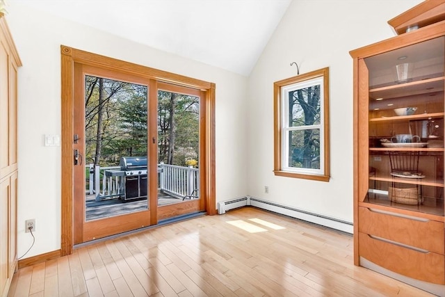 doorway with light wood-style flooring, baseboard heating, and vaulted ceiling