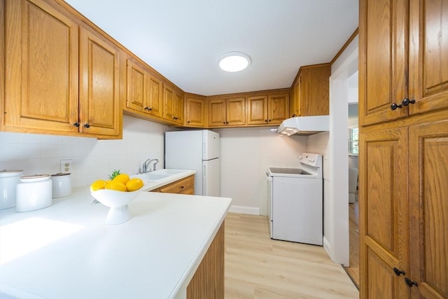 6 Macarthur Rd, Natick, MA 01760 - kitchen with white appliances, under cabinet range hood, brown cabinetry, tasteful backsplash, and light countertops
